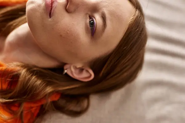Top view of teenage girl with skin concern lying down on couch, zoomer lost in thought — Stock Photo