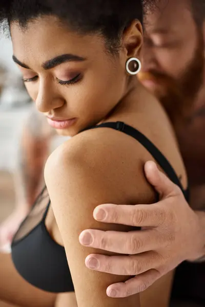 Blurred man touching shoulder of african american girlfriend in lingerie, multicultural sexy couple — Stock Photo