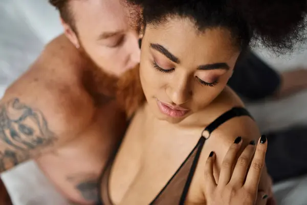 Barbudo hombre besos joven afroamericano novia en sujetador, multicultural sexy pareja - foto de stock