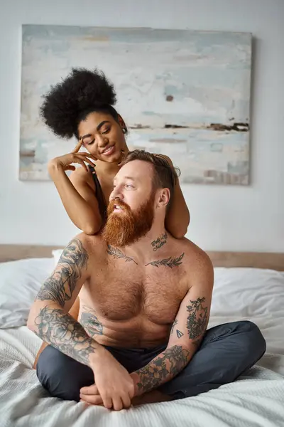 Sexy diverse couple, happy african american woman seducing her tattooed man in bedroom — Stock Photo