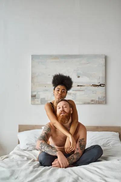 Heureux couple diversifié, sexy afro-américaine femme embrassant son petit ami tatoué à la maison — Photo de stock