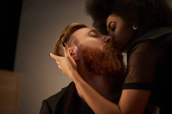 Nuit romantique de couple diversifié dans un cadre intime, femme afro-américaine embrassant homme tatoué — Photo de stock