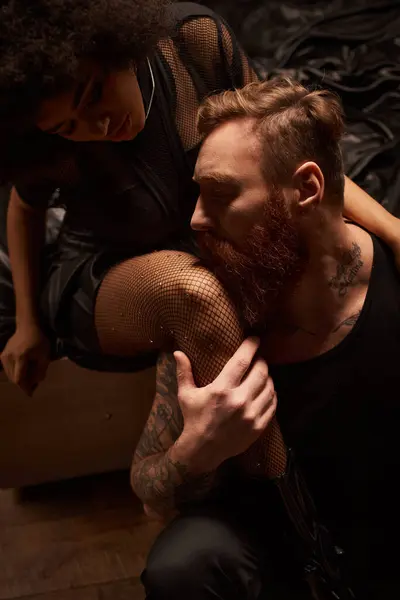 Homme barbu avec des tatouages séduire jeune femme afro-américaine en collants résille avec strass — Photo de stock