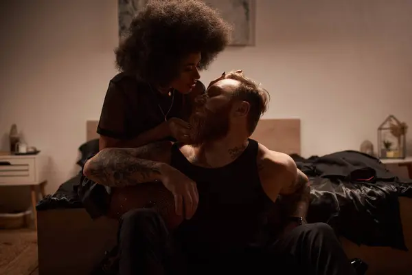 Man with tattoos sitting near seductive african american woman in fishnet tights with rhinestones — Stock Photo