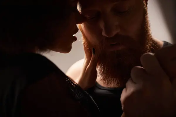 Silhouette of african american woman with curly hair seducing bearded man with red hair, sexy couple — Stock Photo