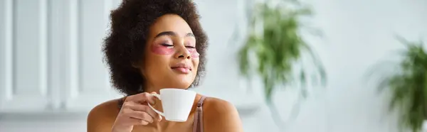 Happy african american woman with eye patches standing in lingerie and enjoying coffee, banner — Stock Photo
