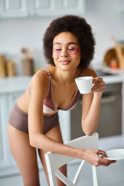 Joyeuse femme afro-américaine avec des patchs debout en sous-vêtements et profiter du café du matin — Photo de stock