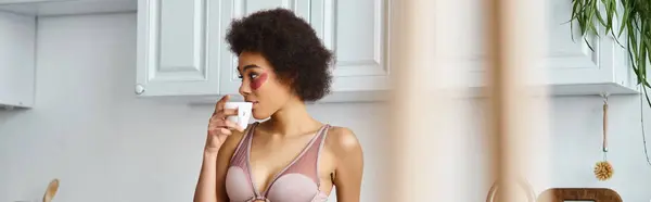Curly african american woman with eye patches standing in underwear and drinking coffee, banner — Stock Photo