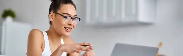 Happy african american woman in glasses working from home remotely on her laptop, video call banner — Stock Photo