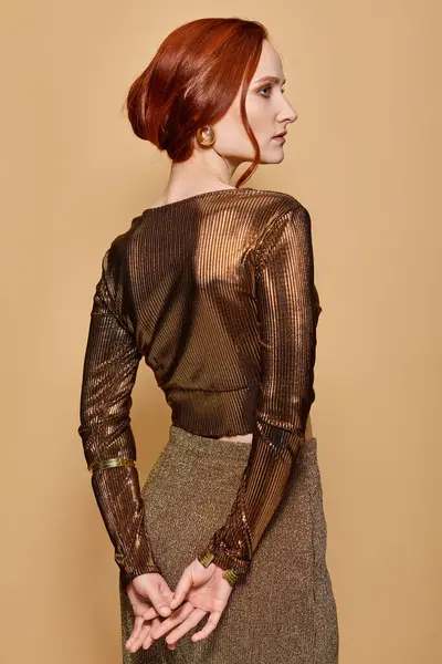 Redhead woman in her 30s posing in trendy attire and golden accessories with hands behind back — Stock Photo