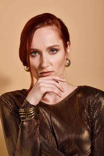 Pretty redhead woman in 30s posing in elegant outfit and golden accessories on beige background — Stock Photo