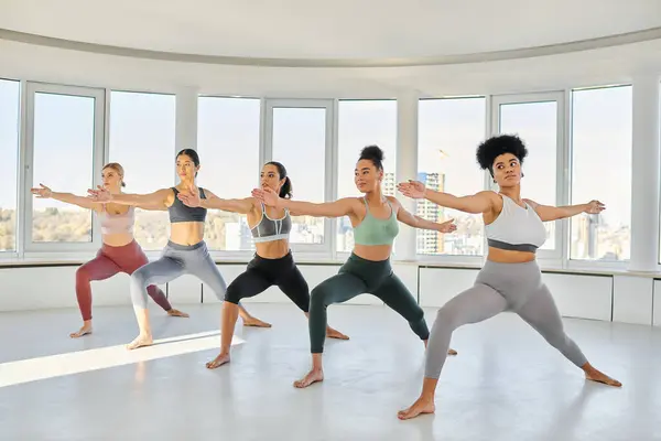 Gruppo di giovani donne diverse in abbigliamento sportivo praticare pilates con le donne africane allenatore americano — Foto stock