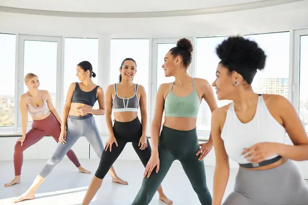 Group of happy diverse women in sportswear practicing pilates with female african american trainer — Stock Photo