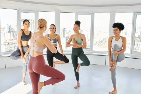 Group of cheerful diverse women in sportswear practicing pilates together with blonde trainer — Stock Photo