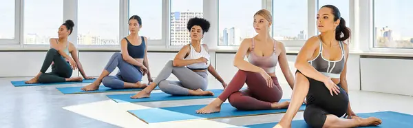 Pancarta de descalzas y jóvenes mujeres multiculturales sentadas en medio señor de peces yoga posan sobre colchonetas - foto de stock