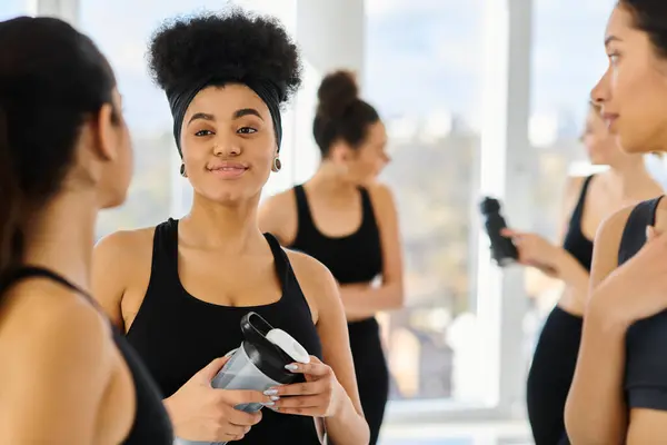Focus on african american sportswoman listening to her female friends while chatting after workout — Stock Photo