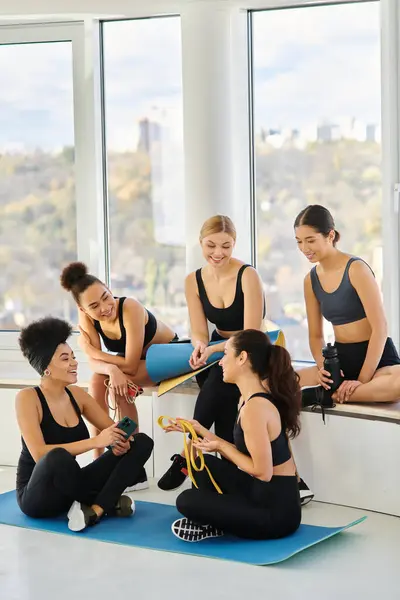 Group of young five interracial woman in sportswear chatting after workout in pilates class, friends — Stock Photo