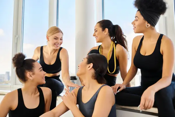 Group of positive five multicultural woman in sportswear chatting after workout in pilates studio — Stock Photo