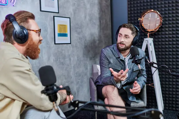 Attractive interviewer with red hair and his guest with headphones discussing questions, podcast — Stock Photo