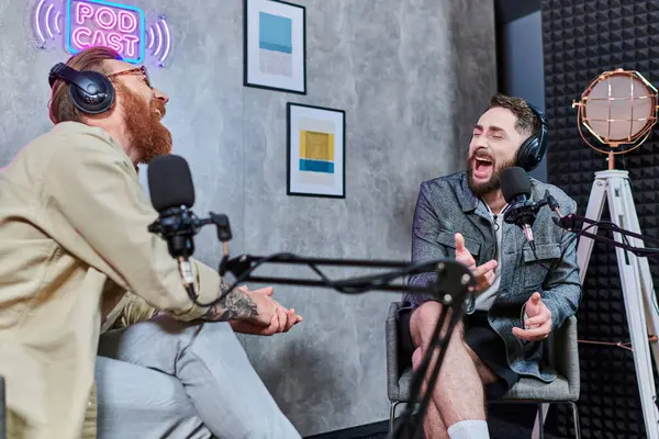 Attractive interviewer with red hair and his guest with headphones discussing questions, podcast — Stock Photo