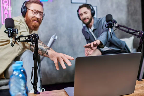 Good looking stylish men with beards and headphones discussing questions in studio during podcast — Stock Photo