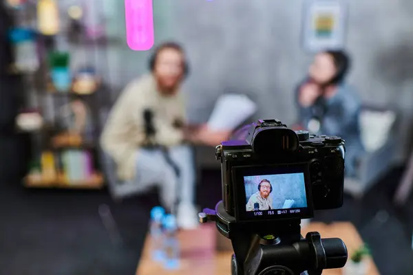 Focus on camera filming handsome blurred men with beards in headphones discussing questions, banner — Stock Photo