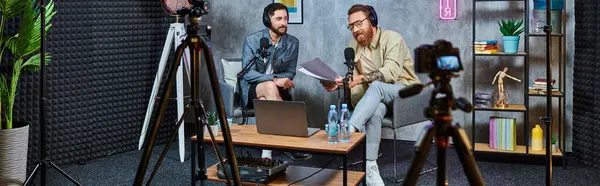 Good looking bearded interviewer talking to his young guest with headphones during podcast, banner — Stock Photo
