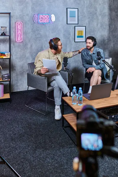 Hard working bearded interviewer discussing main questions with his young guest during podcast — Stock Photo