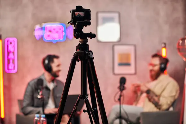 Focus on camera filming stylish blurred men with beards in headphones discussing questions, banner — Stock Photo