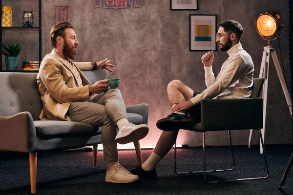 Dedicated men with beards in elegant attires sitting and discussing questions during interview — Stock Photo