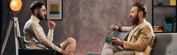 Uomini devoti con la barba in abiti eleganti seduti e discutendo domande durante l'intervista, banner — Foto stock