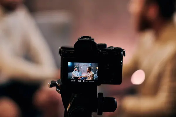 Focus sur la caméra filmant des hommes flous élégants en tenue élégante serrant la main en studio, interview — Photo de stock