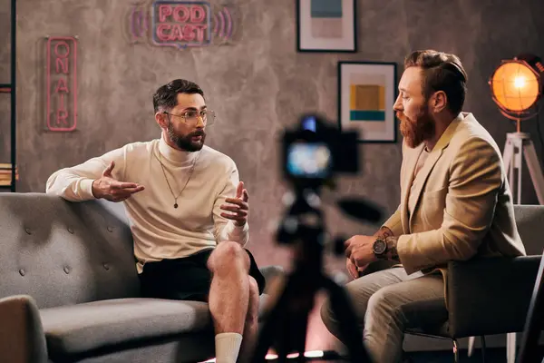 Гарний вигляд бородатих чоловіків в елегантному стильному вбранні, що сидить і обговорює питання інтерв'ю — стокове фото