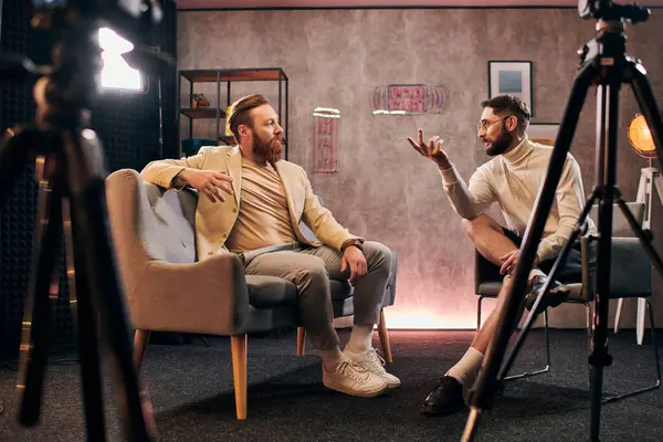 Zwei elegante Männer mit Rauschebärten sitzen im Studio und diskutieren Interviewfragen — Stockfoto