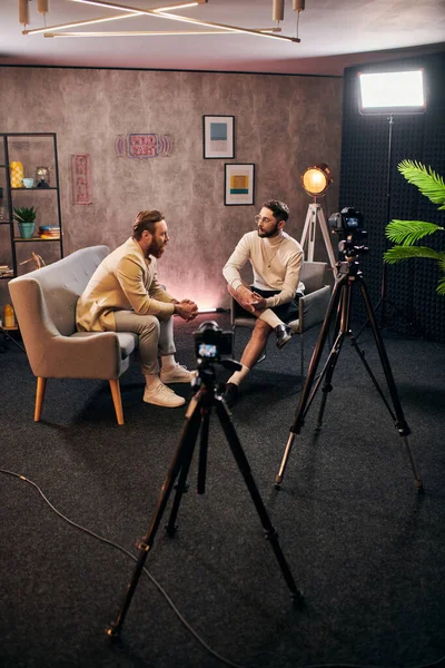 Homens elegantes bonitos com estilo dapper sentado e discutindo perguntas de entrevista em estúdio — Fotografia de Stock