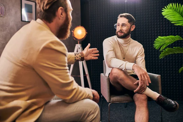 Attractive elegant men in stylish clothes sitting and discussing interview questions in studio — Stock Photo