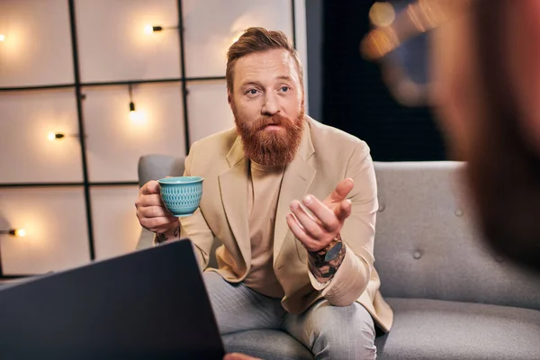 Good looking trendy men in elegant attires with coffee and laptop discussing interview questions — Stock Photo