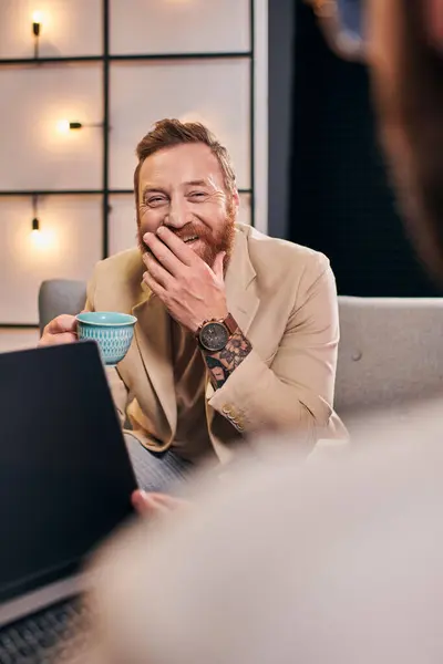 Deux joyeux hommes attrayants dans des vêtements élégants avec café et ordinateur portable discuter des questions d'entrevue — Photo de stock