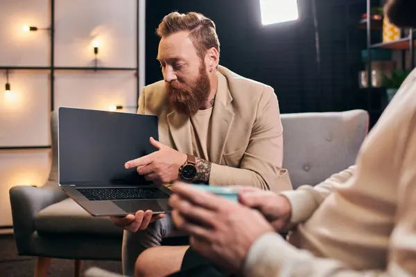Good looking trendy men in elegant attires with coffee and laptop discussing interview questions — Stock Photo