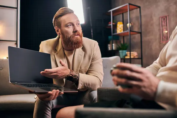 Красивые стильные мужчины в элегантных одеждах с кофе и ноутбуком обсуждают вопросы интервью — стоковое фото