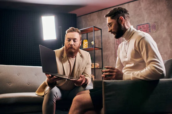 Beaux hommes élégants en tenues élégantes avec café et ordinateur portable discuter des questions d'entrevue — Photo de stock