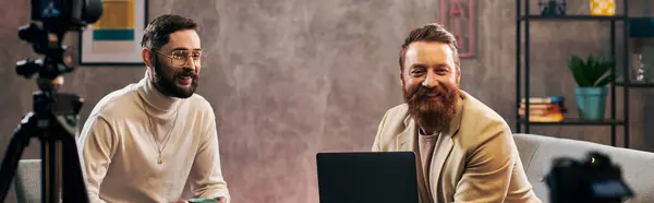 Allegri uomini belli in abiti alla moda con caffè e laptop sorridenti durante l'intervista, banner — Foto stock