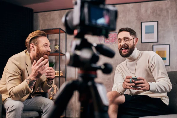 Cheerful elegant bearded men in stylish clothes talking actively during their interview in studio — Stock Photo