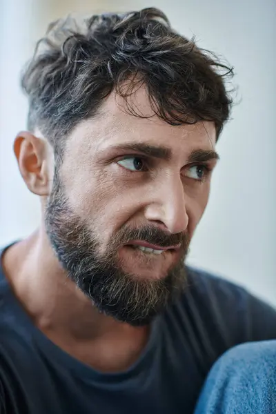 Homme mal traumatisé avec la barbe mordre les lèvres pendant l'épisode dépressif, conscience de la santé mentale — Photo de stock