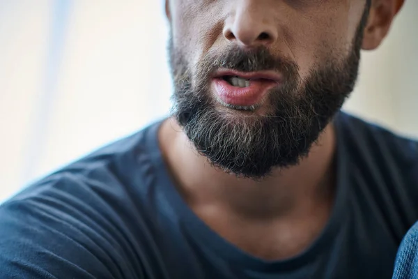 Abgeschnittene Ansicht eines traumatisierten Mannes, der sich während einer depressiven Episode in die Lippen beißt, Bewusstsein für psychische Gesundheit — Stockfoto