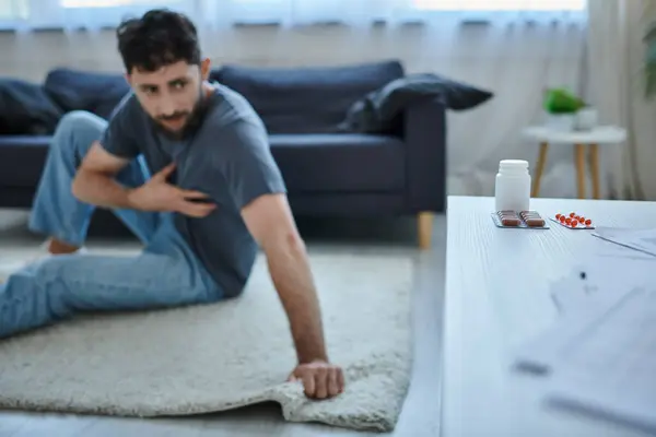 Konzentration auf Tabletten auf dem Tisch mit verschwommenem ängstlichen Mann mit depressiver Episode auf dem Hintergrund, psychische Gesundheit — Stockfoto
