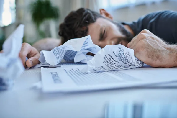 Desperate man next to his papers and contract during depressive episode, mental health awareness — Stock Photo