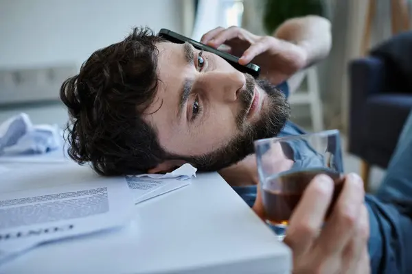 Uomo frustrato che parla da smartphone con alcol nelle mani durante la ripartizione, consapevolezza della salute mentale — Foto stock