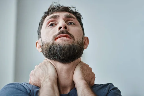 Ängstlicher frustrierter Mann in lässigem T-Shirt beißt sich beim Zusammenbruch die Lippen blutig, psychische Gesundheit — Stockfoto