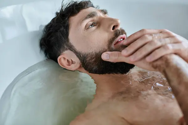 Homme traumatisé déprimé avec barbe allongé dans la baignoire pendant la dépression, conscience de la santé mentale — Photo de stock